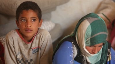 Displaced people who fled Mosul sit inside a tent at a refugee camp in Duhok, Iraq [Reuters]