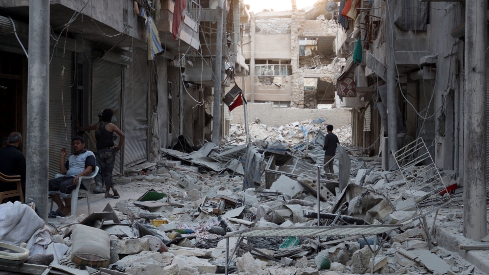 Residents inspect a damaged site after an airstrike in the besieged rebel-held al-Qaterji neighbourhood of Aleppo