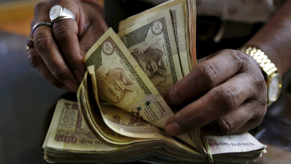 A money lender counts Indian rupee