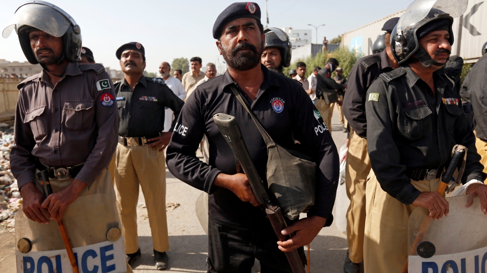 Police stand guard as Shi''ite Muslim men blocked the main national highway and railway tracks to protest the detention of their religious workers in Karachi