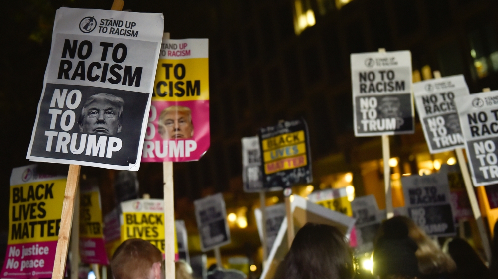 People hold placards at an anti-racism protest against U.S. President-elect Donald Trump outside of the U.S. Embassy in London