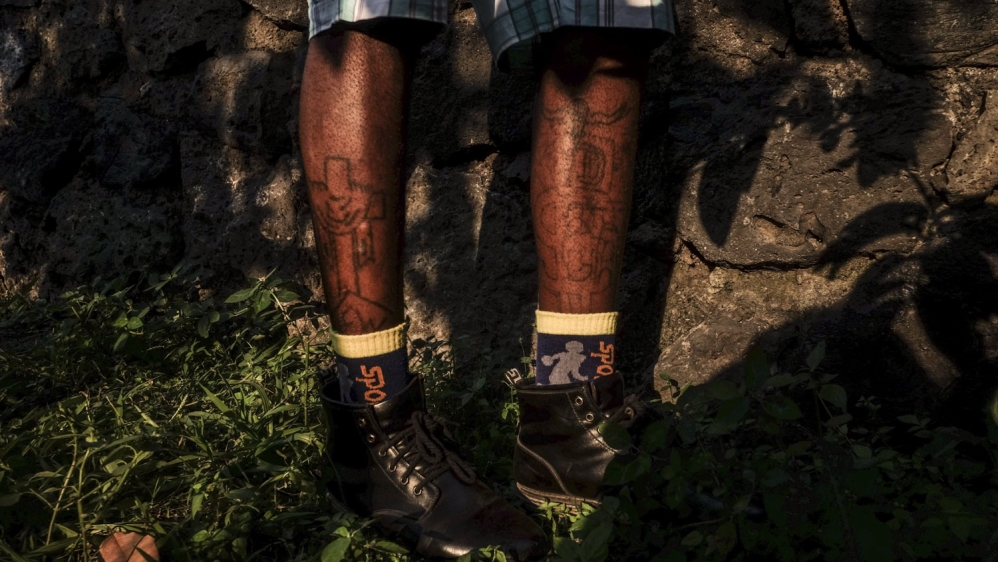 Blaise Kasereka Kihambu, at his house where he lives with his brother in Goma, is a former child soldier. He loves Chinese tattoos [Francesca Volpi/Al Jazeera]