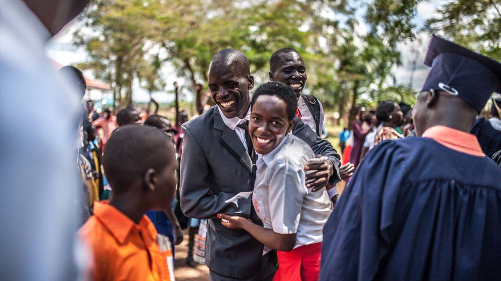 Simon Peter Otoyo celebrates with one of his students, 16-year-old Awello Younes, at Amor Foundation Vocational Training graduation [Aurelie Marrier d'Unienville/Sightsavers/Al Jazeera] 