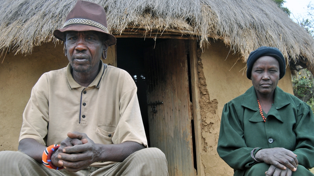 Arap Chebon Lochumunyang', 60, and his wife sit outside their house in Sinoni village. Last year, two of Chebon's sons were killed in cattle rustling-related attacks [Anthony Langat/Al Jazeera]