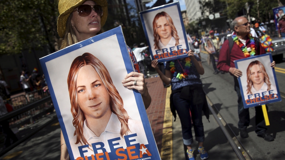 FILE PHOTO -- People hold signs calling for the release of imprisoned wikileaks whistleblower Chelsea Manning while marching in a gay pride parade in San Francisco, California