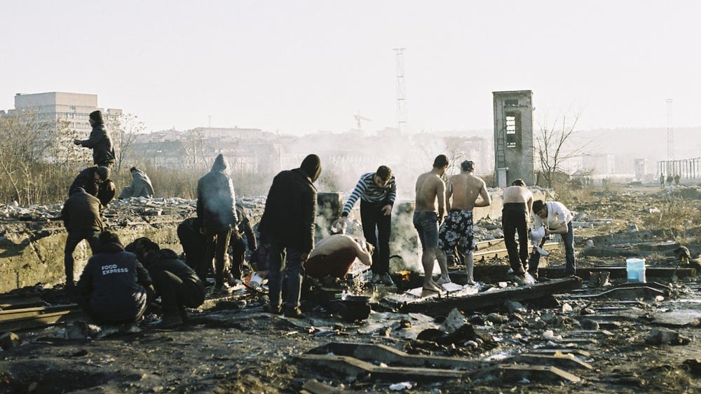 Refugees heat water on campfires to bathe outside in winter weather [Lazara Marinkovic/Al Jazeera]