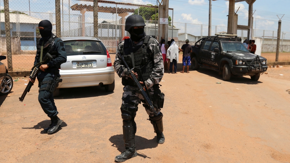 Riot police patrol outside a prison after clashes between rival gang factions in Boa Vista [Reuters]