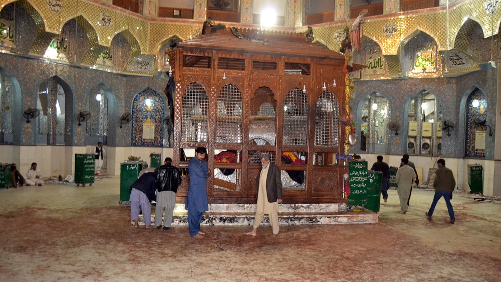 Devotees look at the blood-stained floor of the shrine [Yousuf Nagori/ AFP]