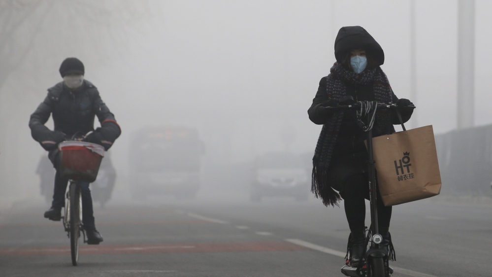 People ride amid the smog in Beijing