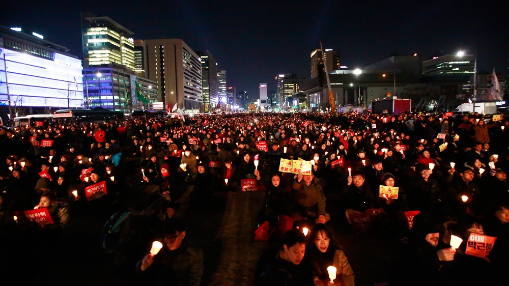 South Koreans holding candles gather in Gwanghwamun Square in the heart of Seoul to celebrate Park's impeachment [EPA/Jeon Heon-Kyun]