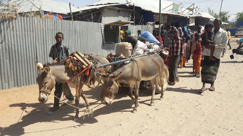 Refugees walk through Doolow town with all their possessions, headed to the border [Fahmida Miller/Al Jazeera]