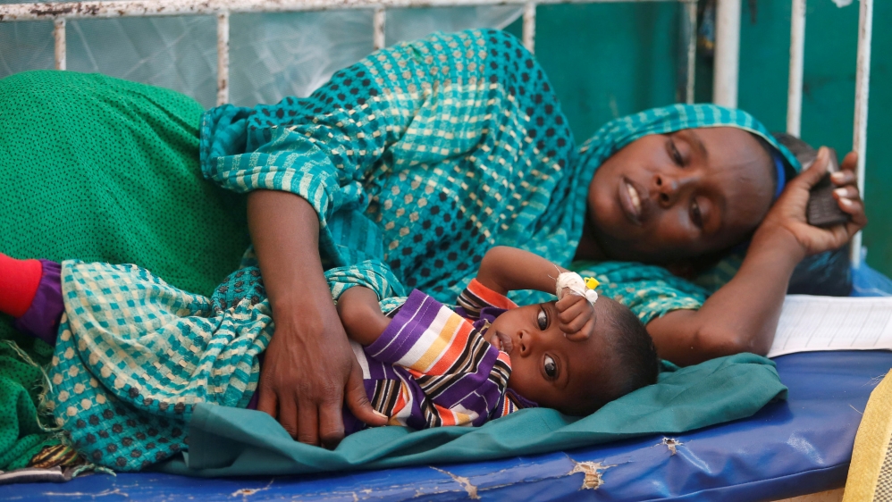 An internally displaced Somali woman holds her child receiving treatment inside a ward dedicated for diarrhoea patients at Banadir hospital in Somalia''s capital Mogadishu