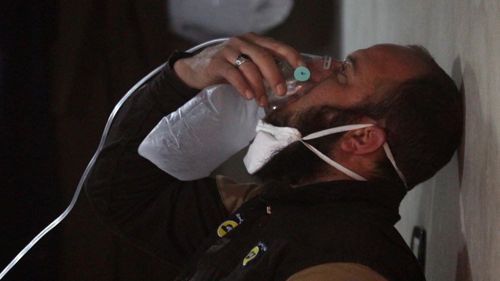 A civil defense member breathes through an oxygen mask, after what rescue workers described as a suspected gas attack in the town of Khan Sheikhoun in rebel-held Idlib