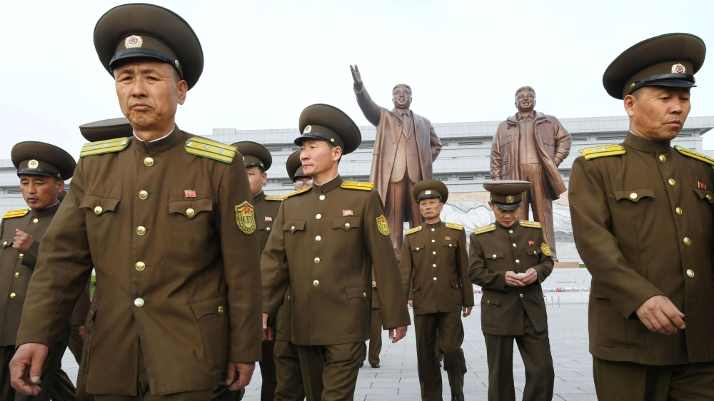 North Korean soldiers walk in front of bronze statues of North Korea''s late founder Kim Il-sung and late leader Kim Jong Il at Mansudae in Pyongyang
