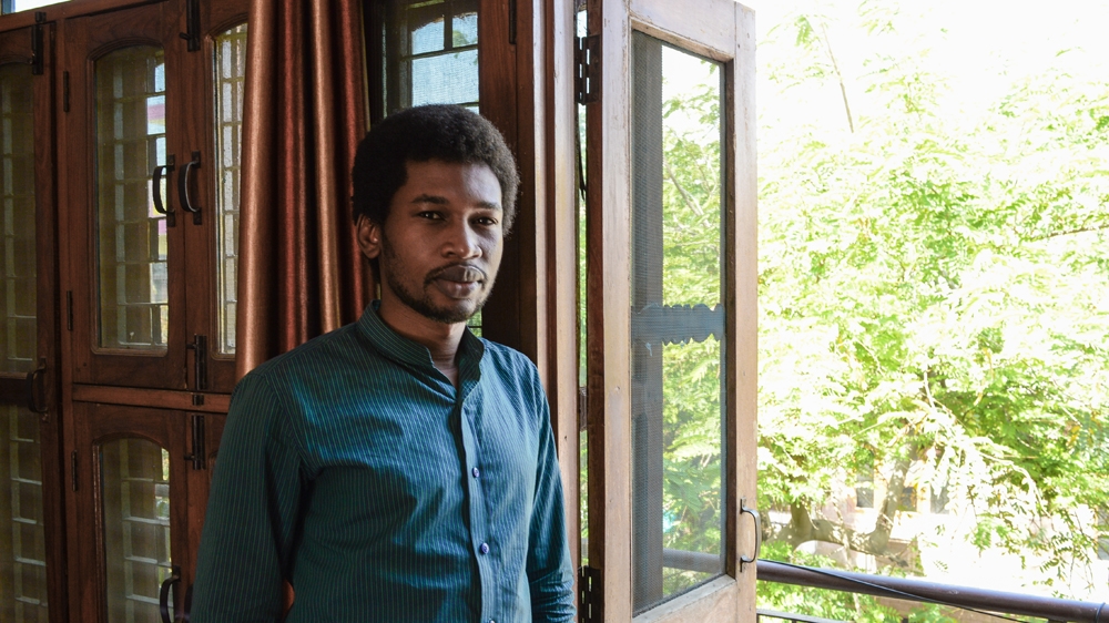 Abdou Brahim Mahamat at home in his Greater Noida apartment, which he calls his 'comfort zone'. 'If I step out, I have to fight,' he says. [Maya Prabhu/Al Jazeera]