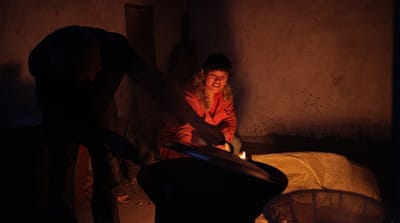 Cai Fengxia's adoptive father cooks for her in Dangshan, eastern China [Han Meng/Al Jazeera]