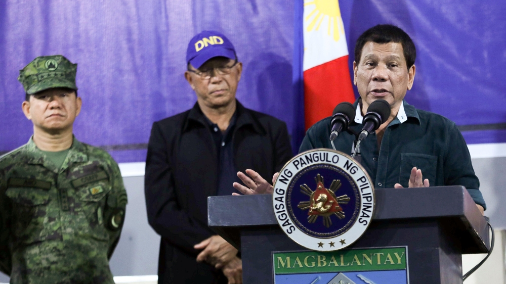 Philippine President Rodrigo Duterte speaks to soldiers next to Defence Secretary Delfin Lorenzana and Armed Forces chief General Eduardo Ano during a visit at a military camp in Iligan