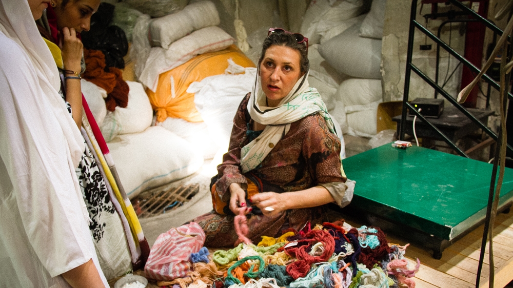 To help preserve Iran's culture and traditions, Shadi Parand thinks it's important to rely on local craftsmen to furnish the hotel. Here, she looks for naturally dyed fabrics [Screengrab/Al Jazeera]