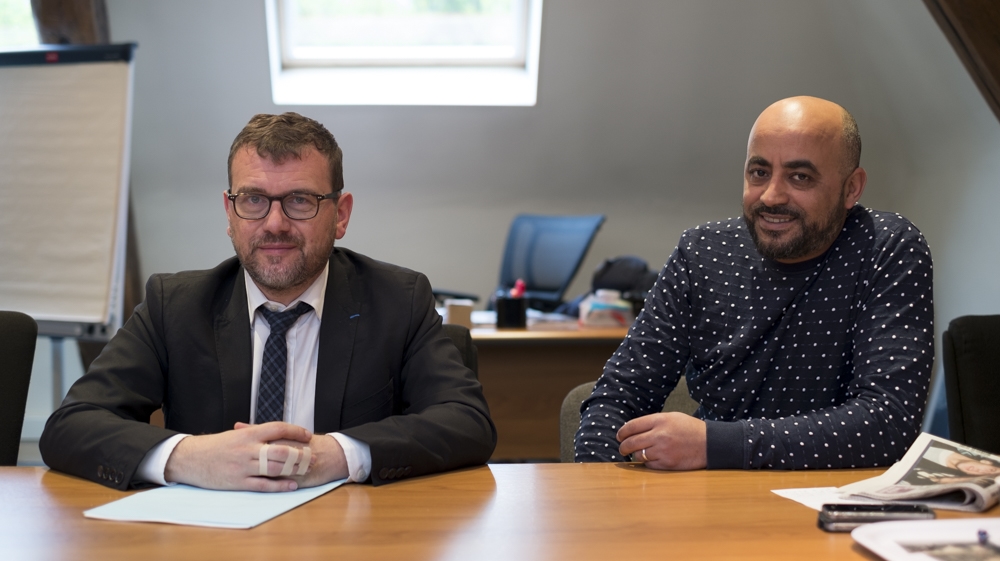 Clichy-sous-Bois mayor, Oliver Klein, right, and deputy Ahmed Bahout discuss improvements in the suburb over the past 12 years [Raymond Bobar/Al Jazeera] 