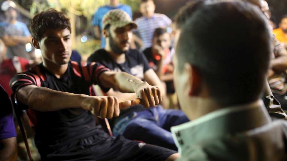 The muhabis (ring) game still brings people together, despite the ongoing conflict and divisions in Iraq [Thaier al-Sudani/Reuters]