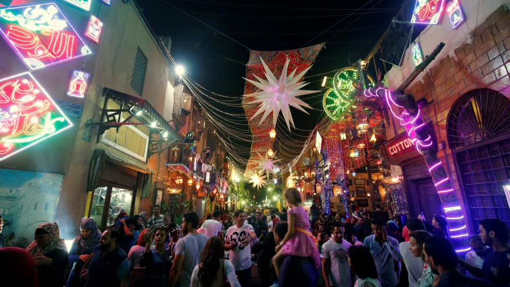 People walk and celebrate after their iftar meal during the Muslim fasting month of Ramadan, on the historic Al Moez Street in old Cairo