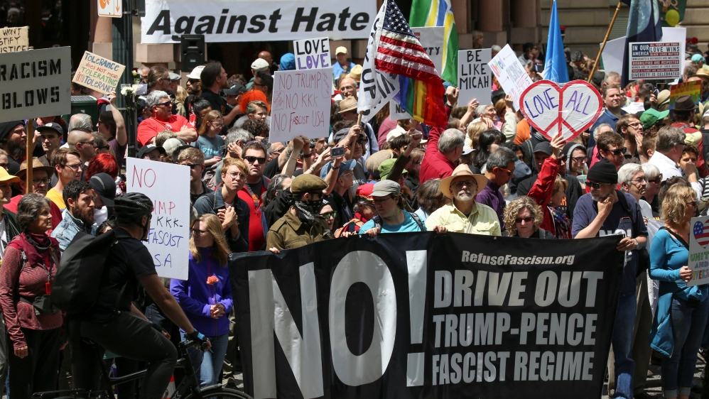 Counter-protesters hold signs across from the Trump Free Speech Rally during competing demonstrations in Portland