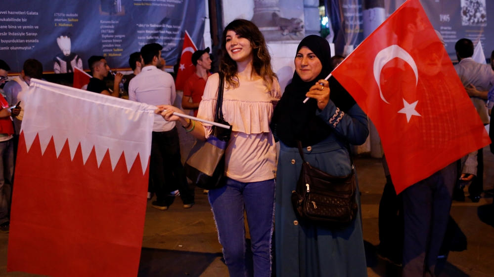 Women pose with Turkish and Qatari flags during a demonstration in favour of Qatar in central Istanbul