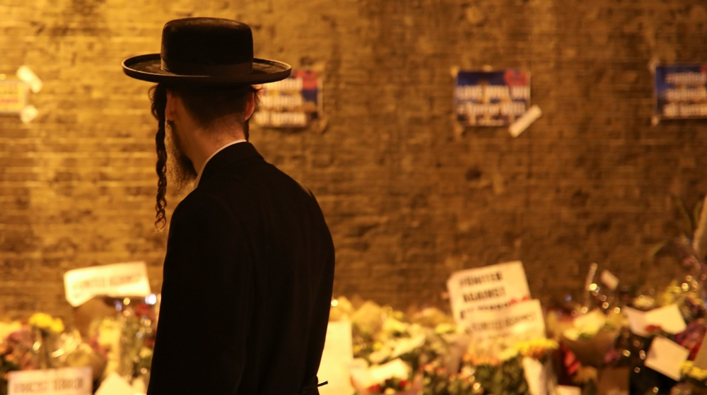 A man walks past floral tributes for victims of Monday's attack [Marko Djurica/Reuters]