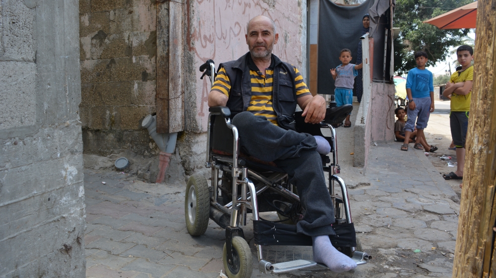 Noman Jibreel sits at the spot where a rocket landed during the 2014 Israeli military offensive, leaving him disabled [Mersiha Gadzo/Al Jazeera]