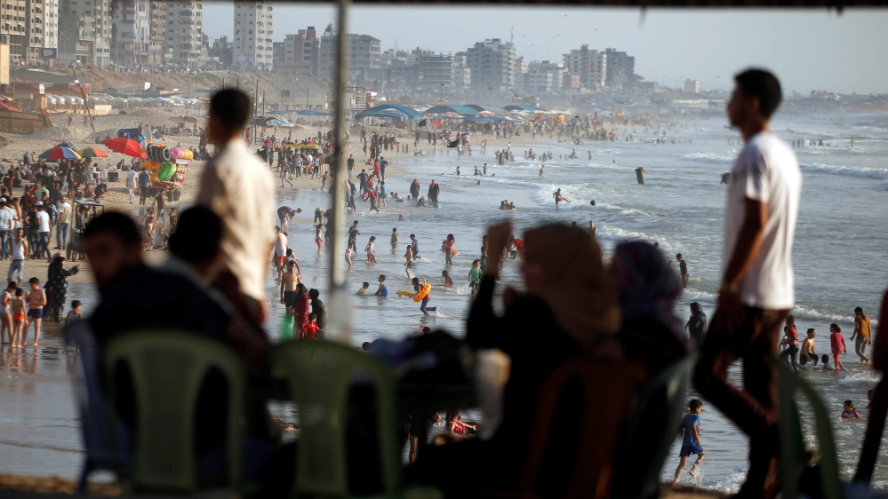 Palestinians spend time on a beach in a warm weather in Gaza City
