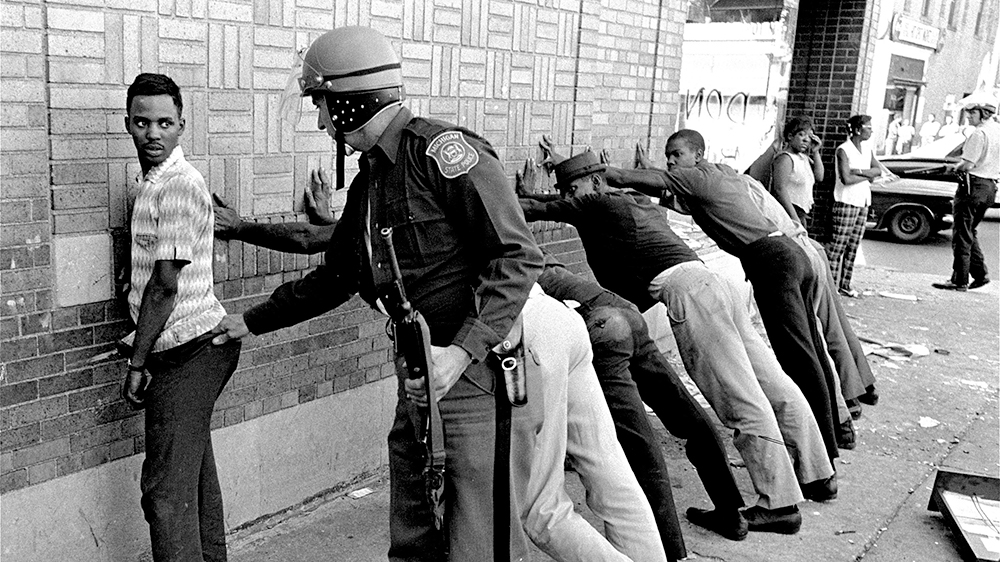 A man is taken into custody by police during riot in Detroit. The riots engulfed the city beginning July 23, 1967 and continued for five days - one of many to hit the U.S. that summer [Alvin Quinn/AP