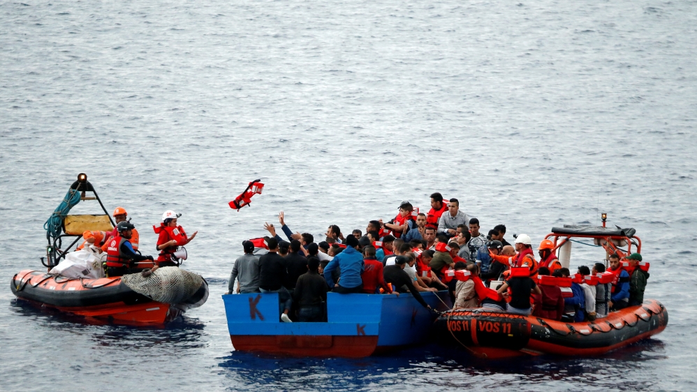 Migrants on a wooden boat are rescued by "Save the Children" NGO crew from the ship Vos Hestia in the Mediterranean sea off Libya coast