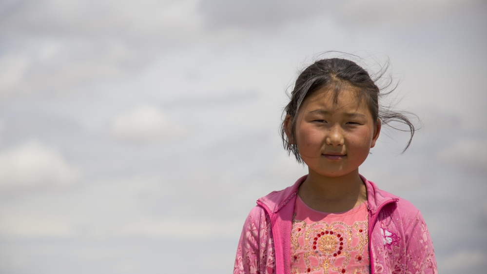 Bujinlkham Damdinsuren outside her family’s ger in Dundgovi Province, Mongolia. Bujinlkham lives with a relative in a nearby town during the school year, as there is no school close to the family [Hannah Griffin/Al Jazeera]