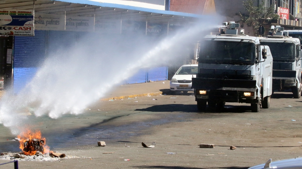 Some young people set fire to cardboard on the streets but police quickly doused the flames [Philimon Bulawayo/Reuters]