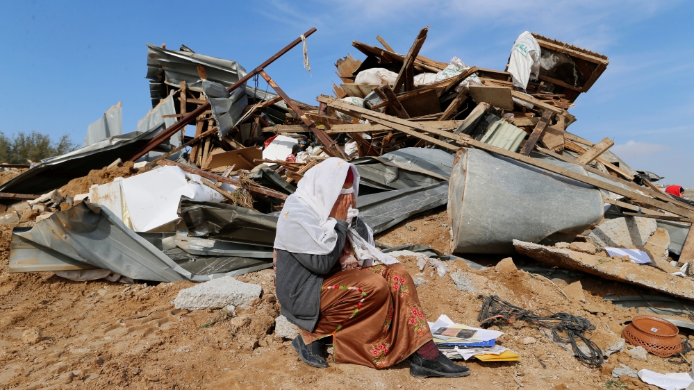 An Arab Israeli woman sits next to ruins from her dwellings which were demolished by Israeli bulldozers in Umm Al-Hiran, a Bedouin village in Israel''s southern Negev Desert
