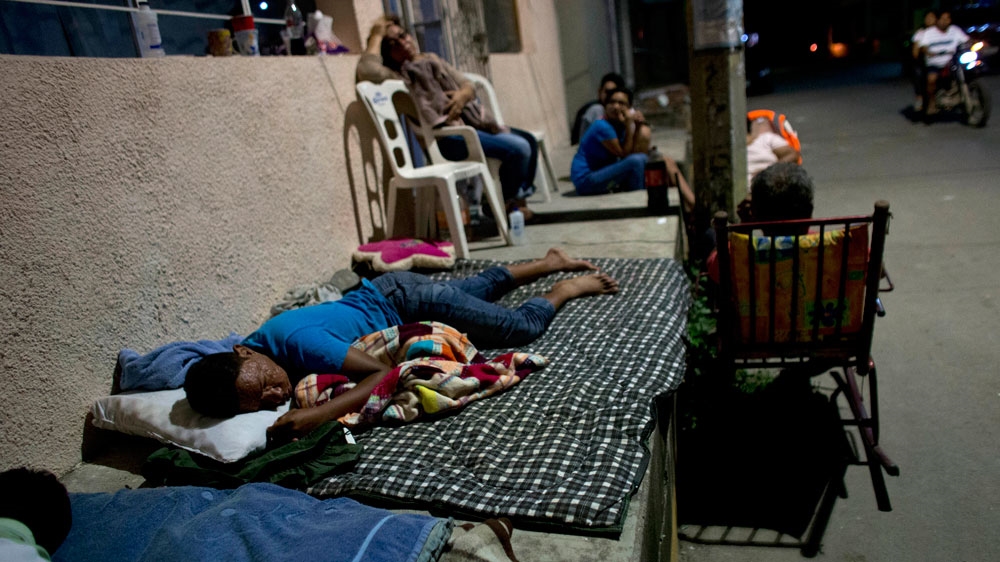 Residents fearing aftershocks sleep on stoops outside their damaged homes in central Juchitan, Oaxaca state [Rebecca Blackwell/AP]
