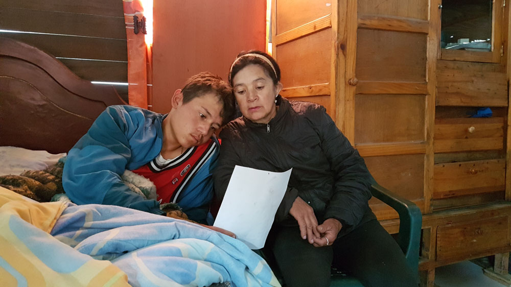 Maria Garzon and her 16-year-old son Jose recently moved to Piedras Blancas. The mother of four says its tough raising a family in the temporary wooden shelter without access to water. The electricity in their small shack is only switched on at night [Dimitri O'Donnell/Al Jazeera]