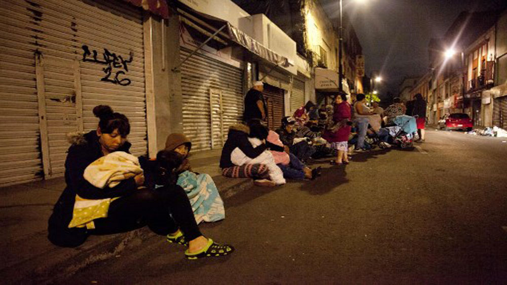People gather on a street in downtown Mexico City during an earthquake on September 7, 2017 [Pedro Pardo/AFP]