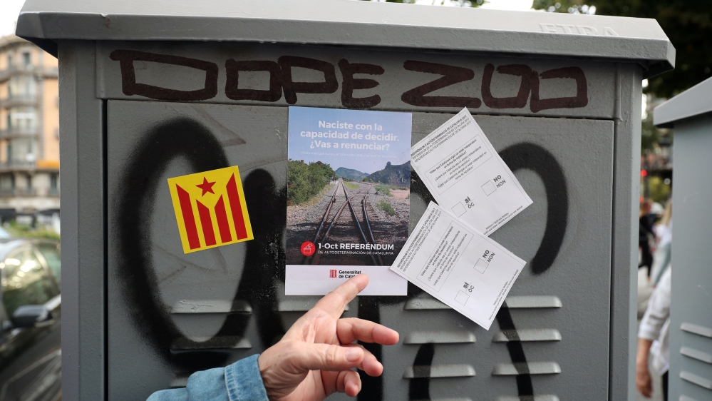 A Catalan pro-independence supporter points at leaflets during a march for the referendum on October 1 in Barcelona