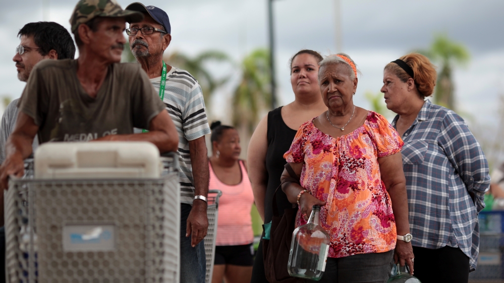 Local residents wait in line during a water distribution in Bayamon following damages caused by Hurricane Maria in Carolina, Puerto Rico