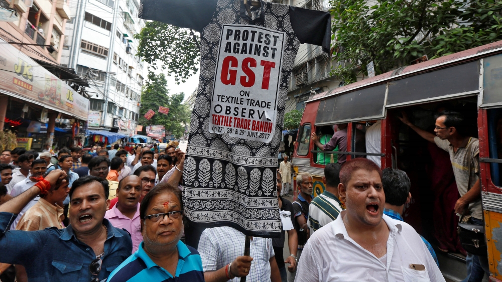 Cloth merchants and workers shout slogans as they carry an effigy depicting Goods and Services Tax (GST) in a market area during a protest rally against implementation of GST on textiles in Kolkata, I