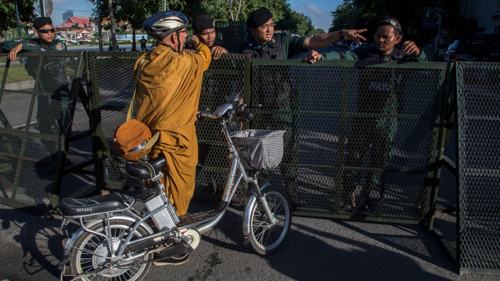 PHNOM PENH, CAMBODIA ñ NOVEMBER 16: A foreign Buddhist monk is stopped by police forces at one of the barricades set up on one of the main avenues with access to the Supreme Court during the hearing o