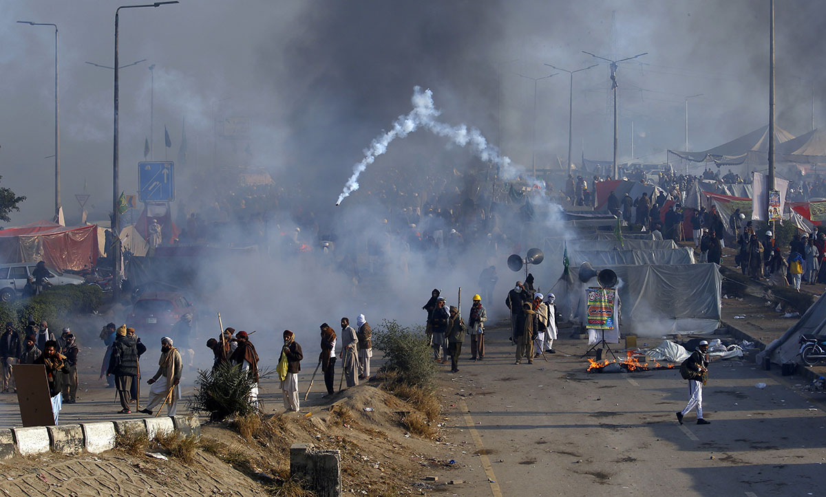 Protesters hurls back a tear gas shell fired by police during a clash in Islamabad, Pakistan, Saturday, Nov. 25, 2017. Pakistani police have launched an operation to clear an intersection linking capi