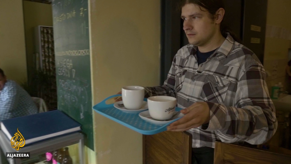 Bartek Jakubowski works at 'Life is Cool' cafe in Warsaw. [Al Jazeera/Marta Kasztelan]