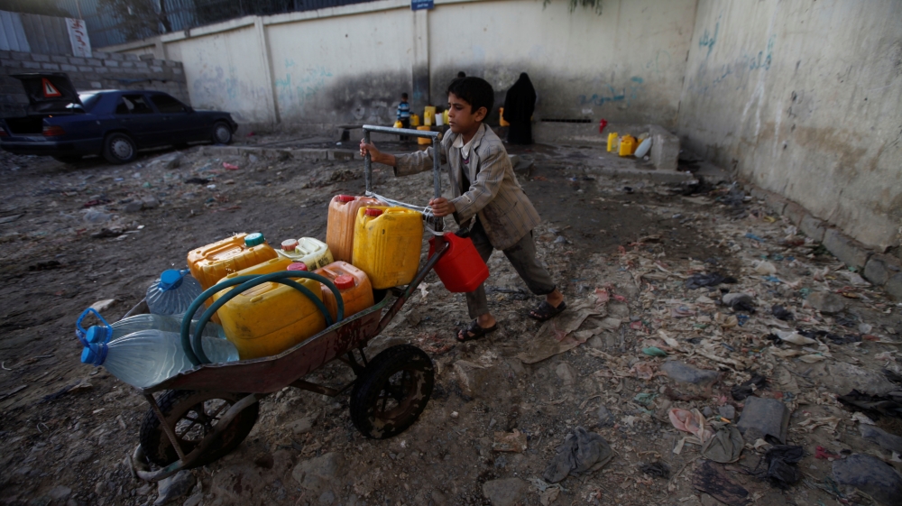 A boy pushes a wheelbarrow filled with water containers after collecting drinking water from a charity tap, amid a cholera outbreak, in Sanaa, Yemen [Mohamed al-Sayaghi/Reuters]