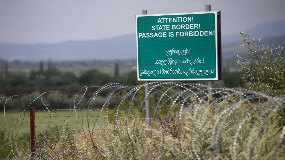 A warning sign is pictured behind a wire barricade erected by Russian and Ossetian troops along Georgia''s de-facto border with its breakaway region of South Ossetia in the village of Khurvaleti