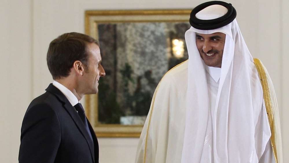 French President Emmanuel Macron with Emir of Qatar Sheikh Tamim bin Hamad al-Thani leave after they have finished their news conference in Doha