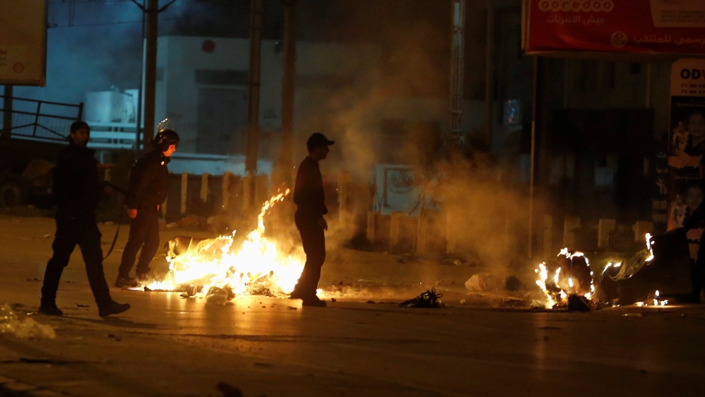 Riot police clash with protesters during demonstrations against rising prices and tax increases, in Tunis