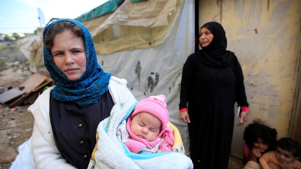 A Syrian refugee woman holds a child in Ain Baal village, near Tyre in southern Lebanon, November 27, 2017. Picture taken November 27, 2017. REUTERS/Ali Hashisho