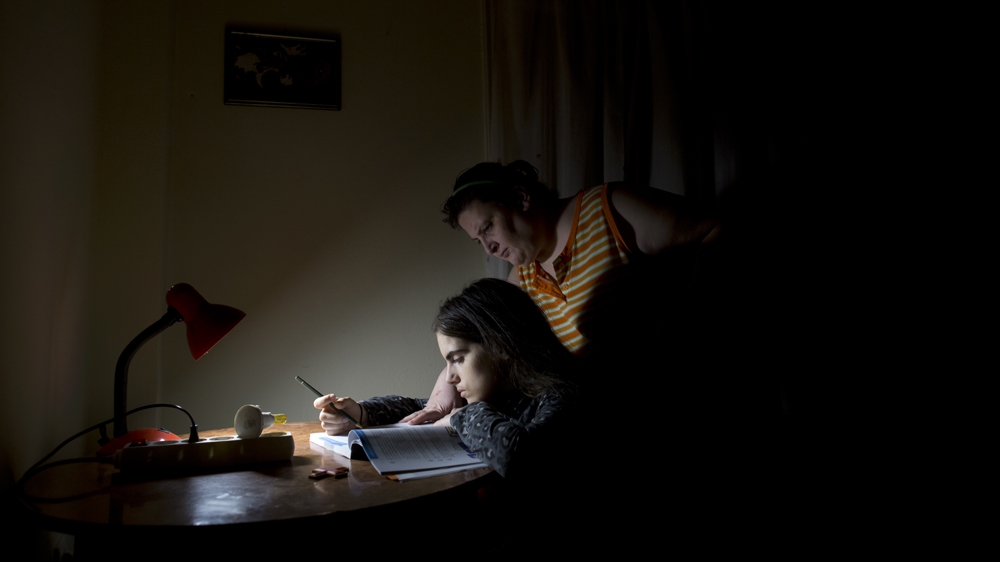 Ioanna helps Christina with her homework [Yannis Kolesidis/Al Jazeera]